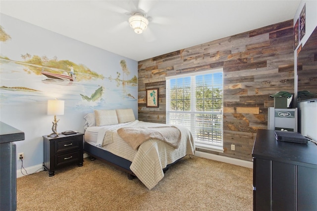 bedroom featuring ceiling fan, carpet, and wood walls