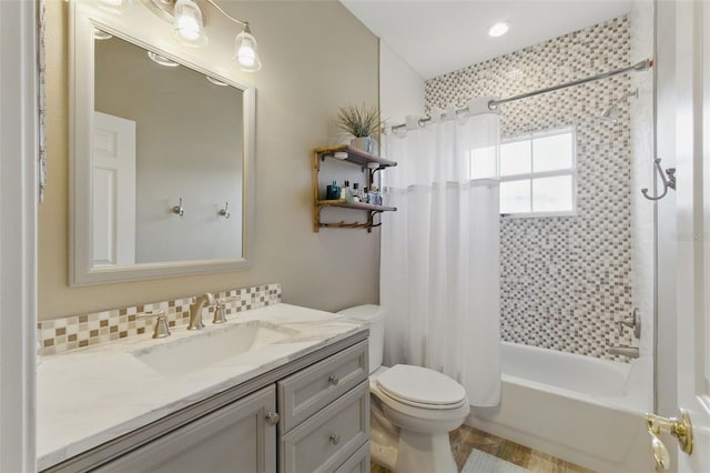 full bathroom featuring decorative backsplash, shower / bath combo, vanity, and toilet