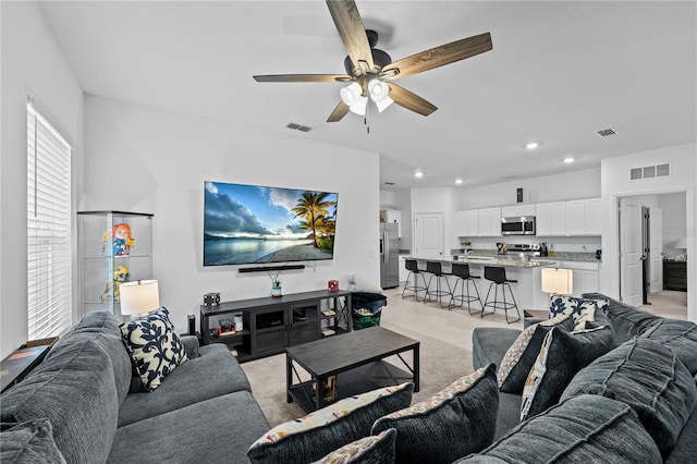 living room with light colored carpet and ceiling fan