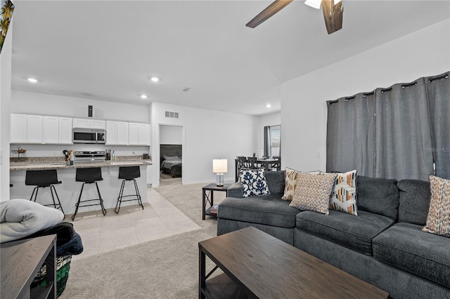 carpeted living room featuring ceiling fan