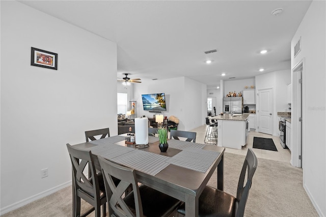 carpeted dining room with ceiling fan