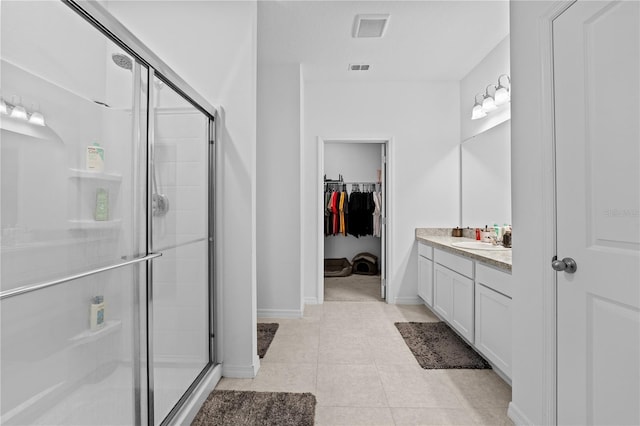 bathroom featuring vanity, tile patterned floors, and walk in shower