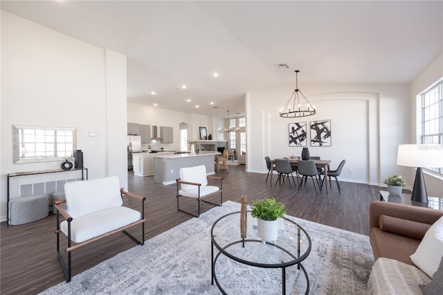 living room with dark wood-type flooring and a chandelier