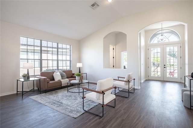 living room featuring vaulted ceiling, dark wood-type flooring, and french doors