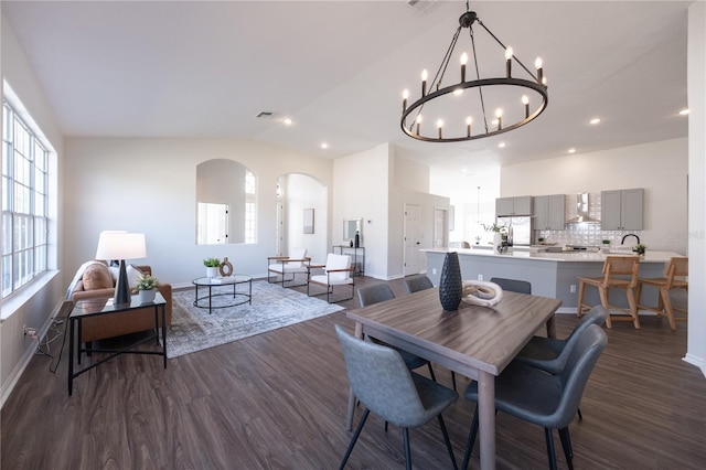 dining space featuring dark hardwood / wood-style flooring, a notable chandelier, and vaulted ceiling