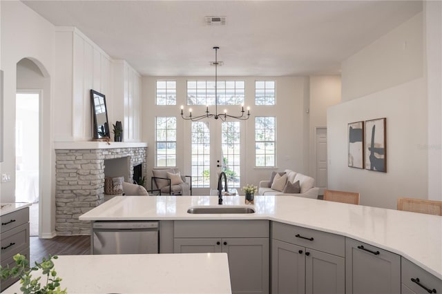 kitchen featuring sink, gray cabinets, dishwasher, dark hardwood / wood-style floors, and decorative light fixtures