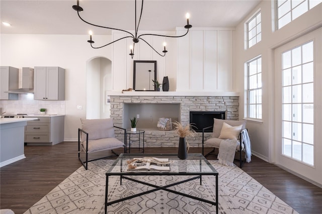 living room featuring an inviting chandelier, plenty of natural light, and dark hardwood / wood-style floors