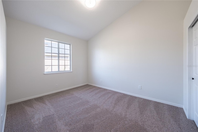 spare room featuring lofted ceiling and carpet