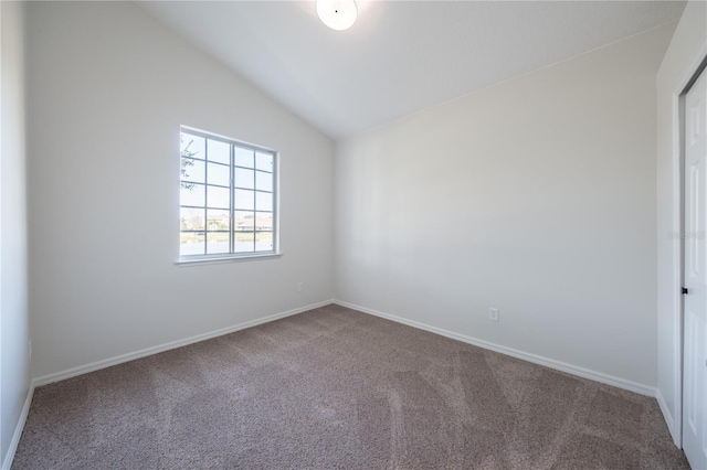 empty room featuring lofted ceiling and carpet