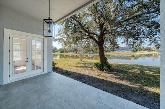 view of patio / terrace with french doors and a water view