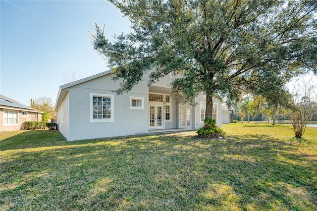 view of front facade with a front yard and french doors