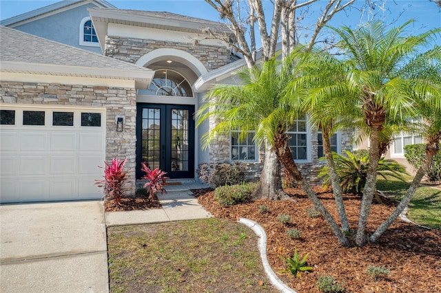 view of exterior entry featuring a garage and french doors