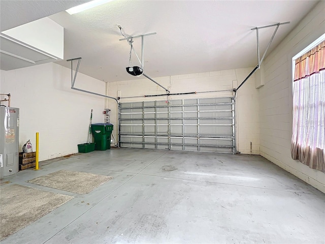 garage featuring concrete block wall, a garage door opener, and water heater