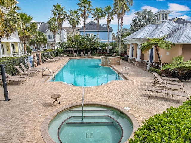 pool featuring a patio, a community hot tub, and fence