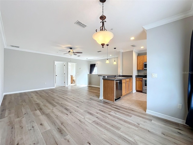 kitchen featuring dark countertops, visible vents, open floor plan, brown cabinets, and appliances with stainless steel finishes