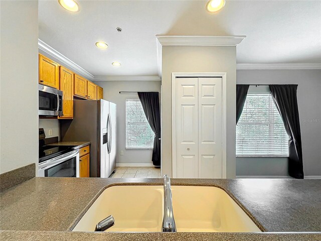 kitchen featuring dark countertops, plenty of natural light, brown cabinets, and appliances with stainless steel finishes