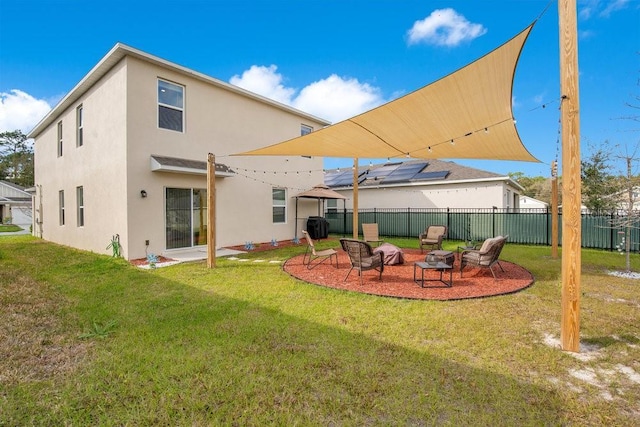 rear view of property with a yard and an outdoor fire pit