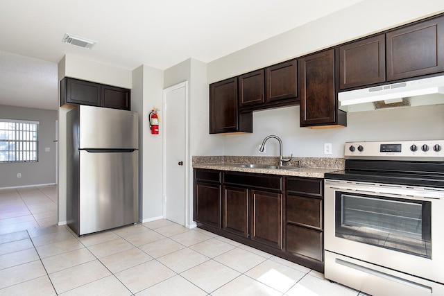 kitchen featuring sink, light tile patterned floors, dark brown cabinets, and appliances with stainless steel finishes