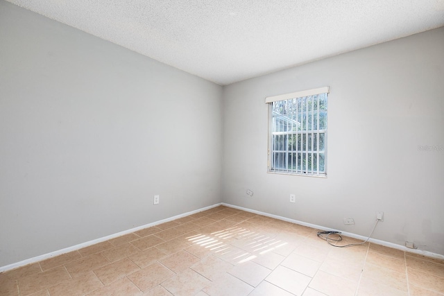 tiled empty room with a textured ceiling