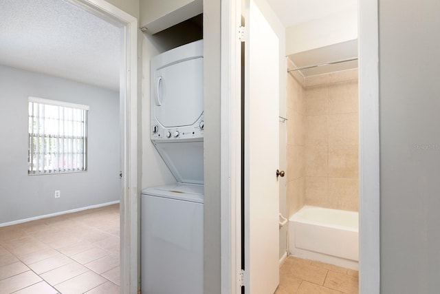 laundry room with light tile patterned flooring and stacked washer / dryer