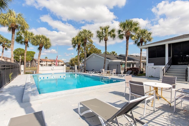 view of swimming pool featuring a patio and a sunroom