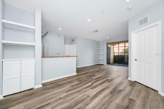 unfurnished living room featuring light hardwood / wood-style flooring, built in features, and ceiling fan