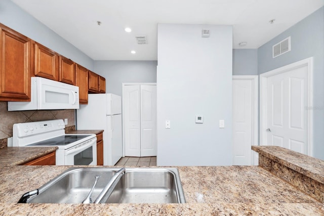 kitchen with tasteful backsplash, sink, and white appliances