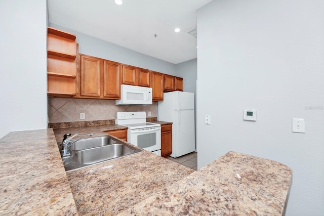 kitchen with sink, white appliances, light tile patterned flooring, decorative backsplash, and kitchen peninsula