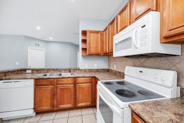 kitchen with sink, white appliances, light tile patterned floors, and backsplash