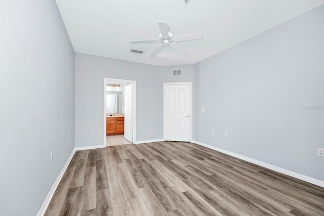 unfurnished bedroom featuring ceiling fan, connected bathroom, and light wood-type flooring