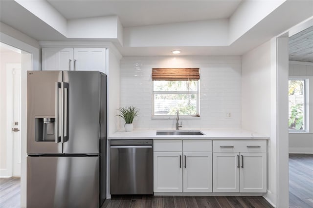 kitchen with white cabinetry, stainless steel appliances, sink, and tasteful backsplash