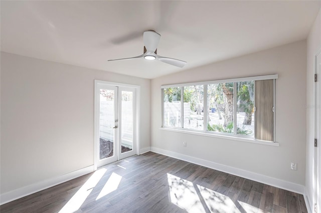 empty room with french doors, ceiling fan, and dark wood-type flooring