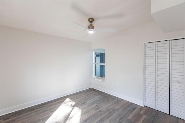 unfurnished bedroom with dark wood-type flooring, a closet, and ceiling fan