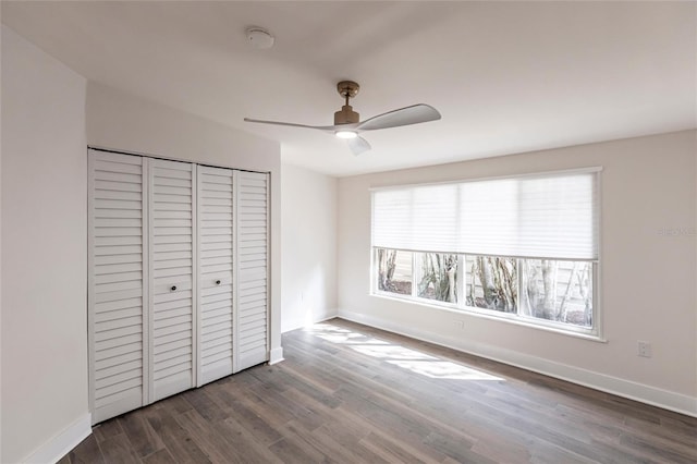 unfurnished bedroom with a closet, dark hardwood / wood-style floors, and ceiling fan