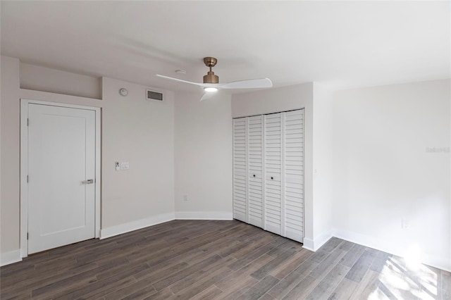 unfurnished bedroom with dark wood-type flooring, ceiling fan, and a closet