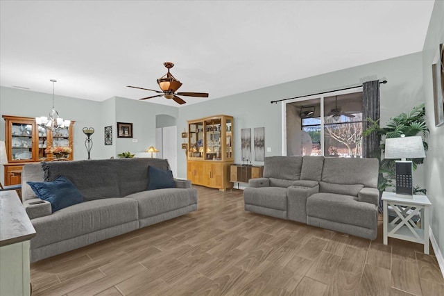 living room with hardwood / wood-style flooring and ceiling fan with notable chandelier