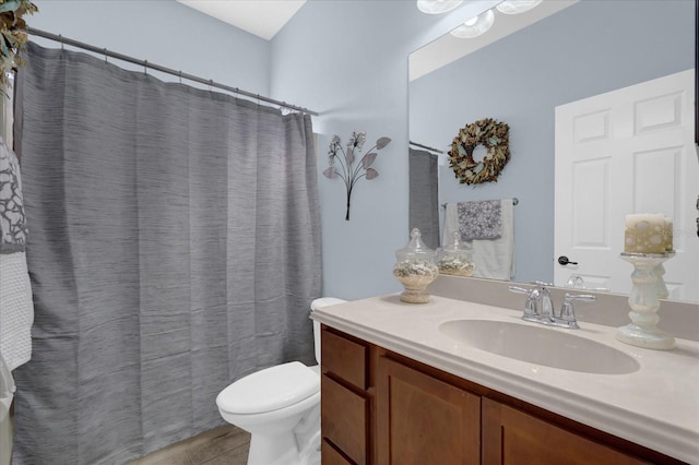 bathroom with tile patterned floors, vanity, toilet, and curtained shower