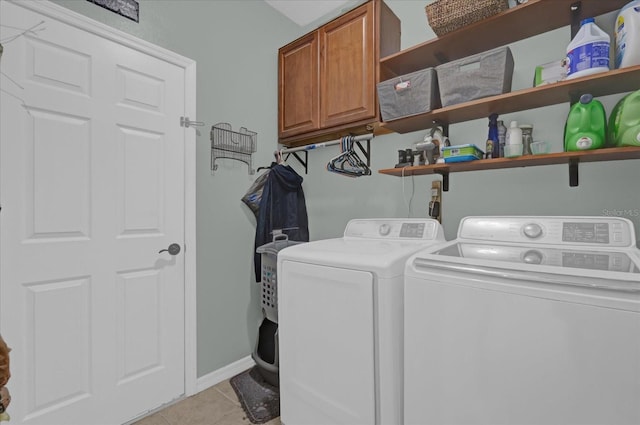 washroom featuring cabinets, washer and dryer, and light tile patterned flooring