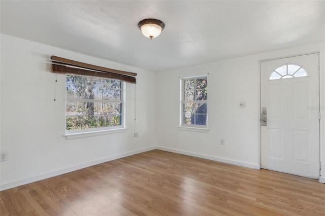 foyer entrance with plenty of natural light, light wood-style flooring, and baseboards