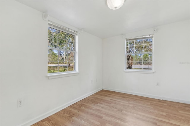 empty room with baseboards and wood finished floors