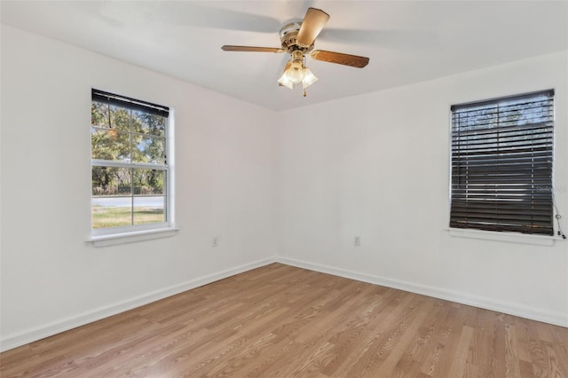 unfurnished room with light wood finished floors, a ceiling fan, and baseboards