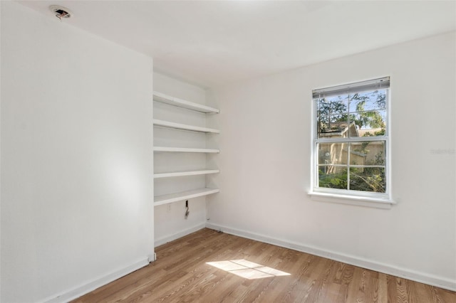 spare room featuring wood finished floors and baseboards