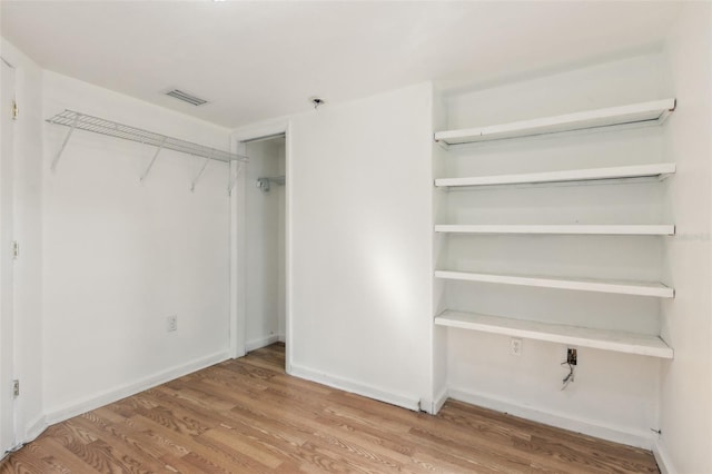 unfurnished bedroom with visible vents, baseboards, and wood finished floors