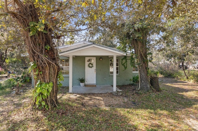 bungalow-style home featuring stucco siding