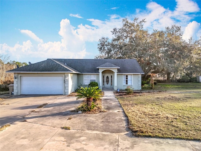 ranch-style home with a garage and a front lawn