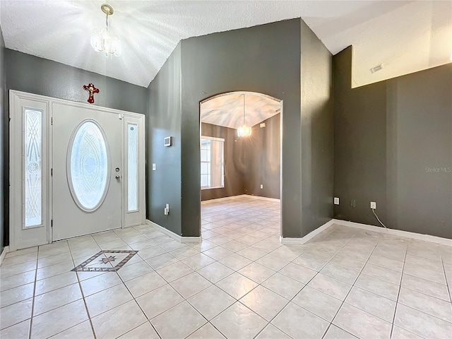 tiled foyer with an inviting chandelier