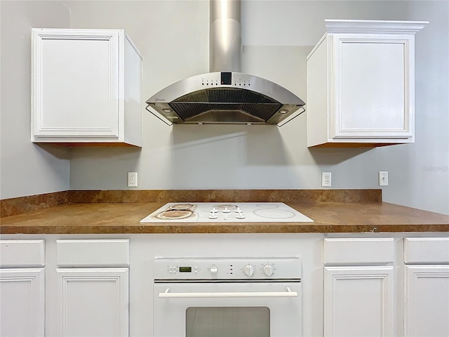 kitchen with white cabinetry, white appliances, island range hood, and wood counters