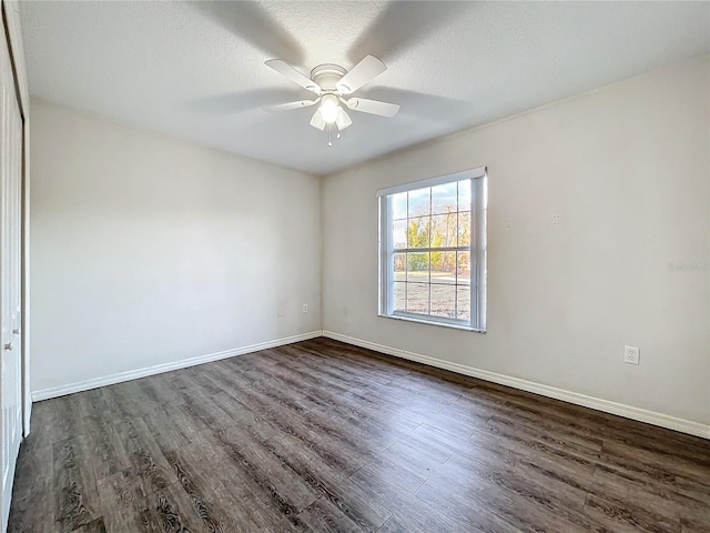 spare room with dark wood-type flooring, a textured ceiling, and ceiling fan