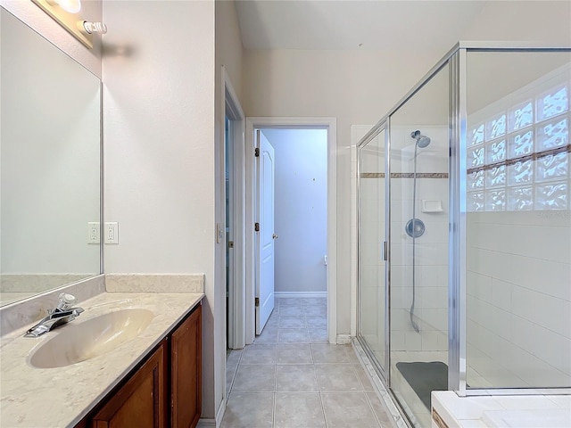 bathroom featuring tile patterned flooring, vanity, and walk in shower