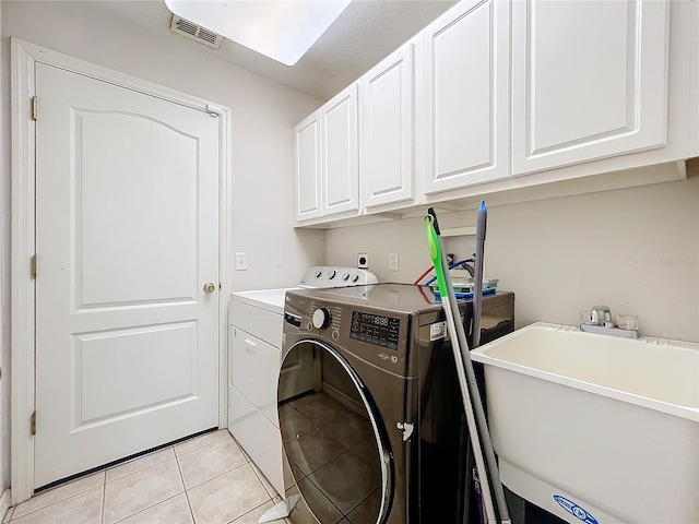 laundry room with light tile patterned flooring, cabinets, separate washer and dryer, and sink